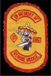 Dieses gelbe Kennzeichen mit roter Umrandung in Form eines Rechtecks mit abgerundeten Ecken, zeigt einen nach links blickenden dickbäuchigen Mann mit Sombrero, in dem sich zwei Einschusslöcher befinden. Pistole und Schwert hält er in den Händen. Links des Mannes ist das rotumrandete, gelbe, rautenförmige „Ein Prozentzeichen“ abgebildet, rechts in einem rotumrandeten gelben Viereck, die Abkürzung „MC“. In einem nach obenhin gerundeten und rot umrandeten Bogen steht in roten Großbuchstaben „IN MEMORY OF“, übersetzt in Gedenken an. In einem nach untenhin gerundeten und rot umrandeten Bogen steht dann der Name eines Mitglieds, wessen gedacht werden soll.