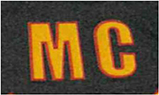 Das Kennzeichen zeigt die Buchstabenfolge M C in gelben Großbuchstaben mit roter Umrandung.