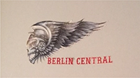„Death Head“ des „HAMC Berlin Central“: geflügelter Totenkopf mit den Initialen „BC“ für „Berlin Central“ hier beispielhaft als Schwarzweißzeichnung und zusätzlich mit dem Schriftzug „BERLIN CENTRAL“, rote Schrift, Schriftart „hessian regular“, versehen