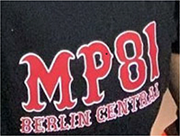 Schriftzug „MP 81 BERLIN CENTRAL“, rote Schrift, weiß umrandet, Schriftart „hessian regular“, wobei der Bestandteil „MP 81“ oberhalb von „BERLIN CENTRAL“ angeordnet und deutlich hervorgehoben ist.