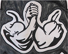 Das Kennzeichen zeigt zwei verschränkte, muskulöse Arme. Die Hände sind ineinander verschränkt.