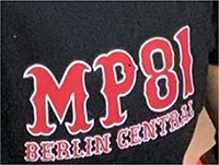 Schriftzug „MP 81 BERLIN CENTRAL“, rote Schrift, weiß umrandet, Schriftart „hessian regular“, wobei der Bestandteil „MP 81“ oberhalb von „BERLIN CENTRAL“ angeordnet und deutlich hervorgehoben ist.